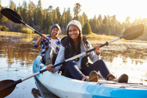 Two african american people kayaking in a lake
